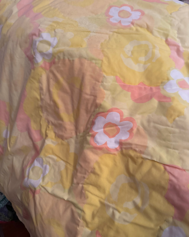 Floral-patterned fabric with yellow flowers and pink centers.